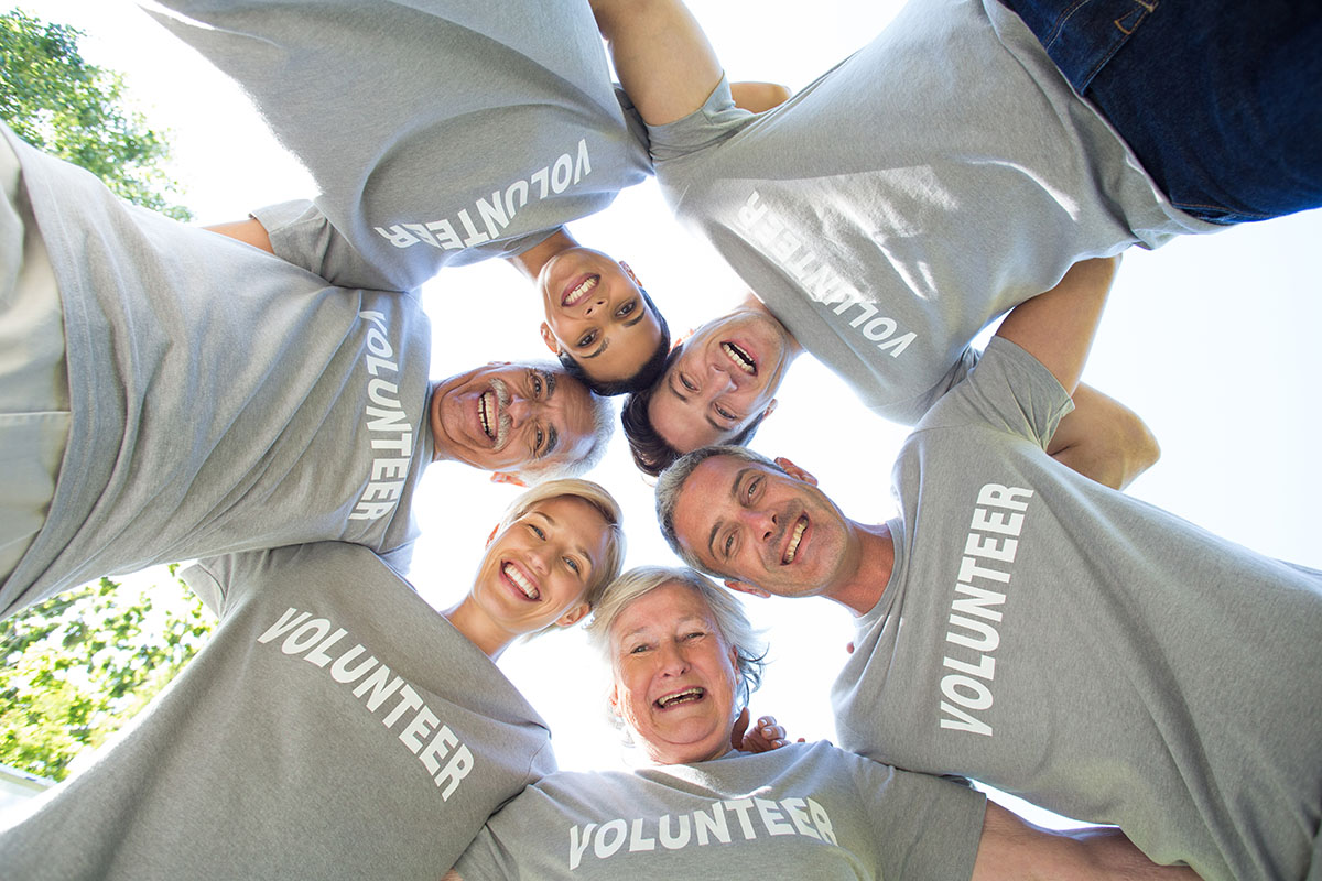 Happy volunteer family looking down at the camera on a sunny day